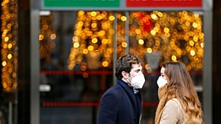 Una coppia con mascherina Ffp2 all'entrata della Galleria Alberto Sordi a Roma