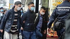 Editor of "Stand News" Patrick Lam, second from left, is arrested by police officers in Hong Kong, Dec. 29, 2021. 