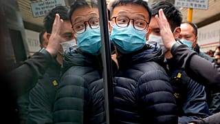 El editor de Stand News Patrick Lam, escoltado por agentes de policía a una furgoneta, 29/12/2021, Hong Kong, China