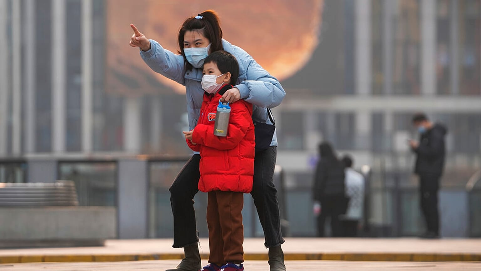 Une femme et un enfant, portant des masques, à Pékin, le 28 novembre 2021