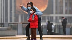 Une femme et un enfant, portant des masques, à Pékin, le 28 novembre 2021