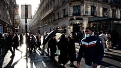 People walk down the Champs Elysees avenue, in Paris, Tuesday, Dec. 28, 2021.