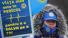 "Veszélyben van az életem, hogy megmentsem a tiédet" - áll egy román egészségügyi dolgozó tábláján. Kórházi dolgozók tüntettek Bukaresten kedden bérnövelést követelve.