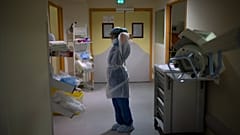 A radiographer prepares to enter the room of a COVID-19 patient in the continued care unit at the Timone hospital in Marseille, France, Dec. 24, 2021.