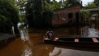 Lucas Ancelmo navega hacia su casa en las aguas de la inundación en Vila Juerana, una zona rural de Ilheus, estado de Bahía, Brasil, miércoles, 29 de diciembre de 2021