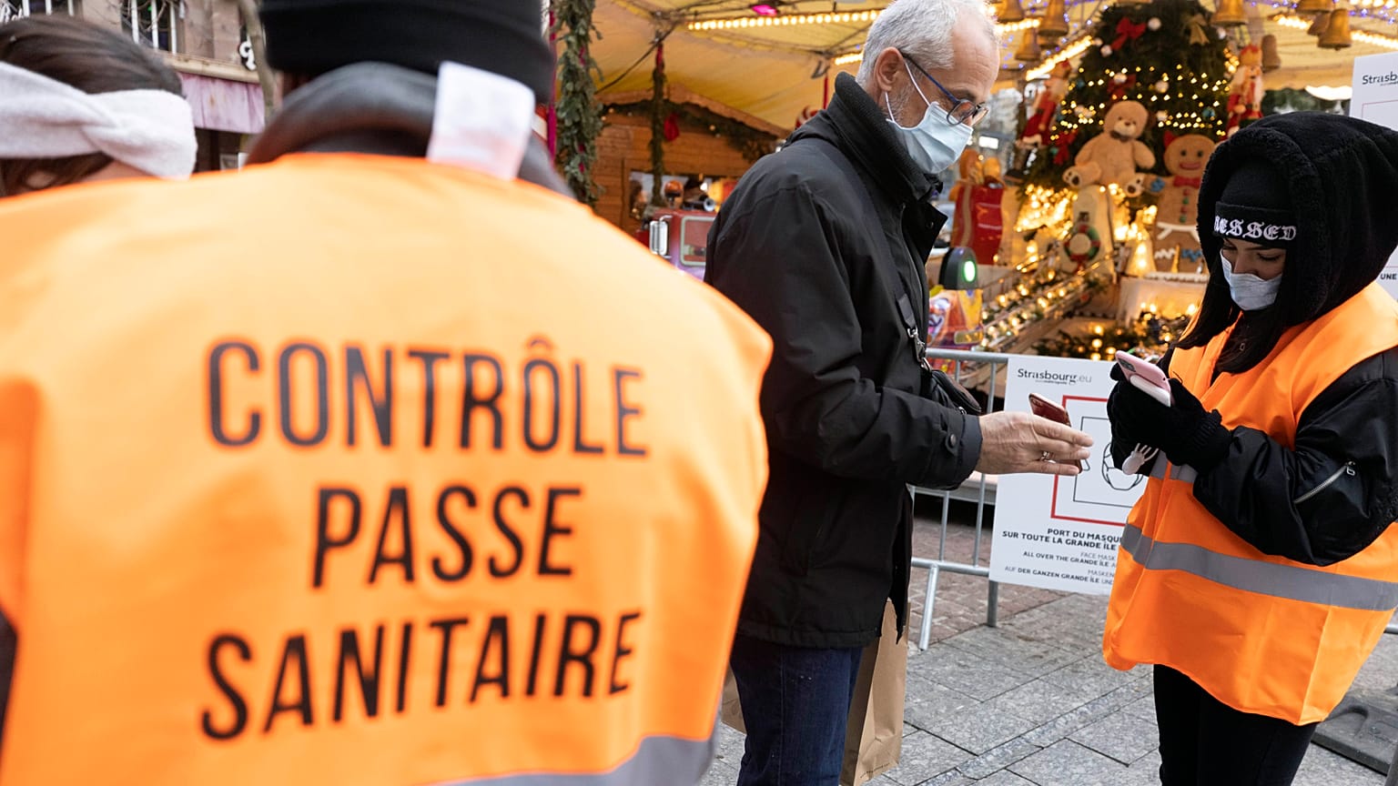 Security personnel check a COVID-19 health pass to access a Christmas market in Strasbourg, eastern France, Friday, Dec 3, 2021.