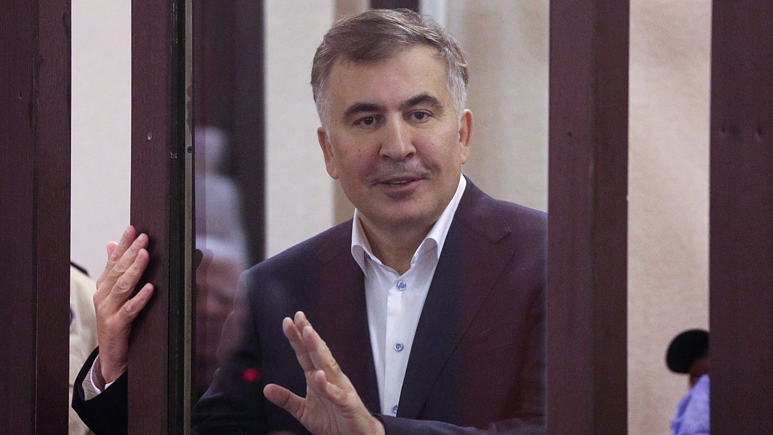 Former Georgian President Mikheil Saakashvili is seen from a defendant's dock during a court hearing in Tbilisi, Georgia, on Dec. 2, 2021.