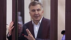 Former Georgian President Mikheil Saakashvili is seen from a defendant's dock during a court hearing in Tbilisi, Georgia, on Dec. 2, 2021.