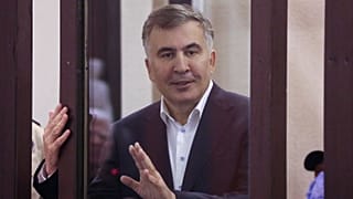 Former Georgian President Mikheil Saakashvili is seen from a defendant's dock during a court hearing in Tbilisi, Georgia, on Dec. 2, 2021.