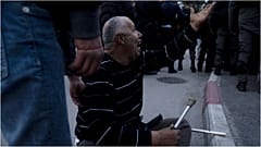 ناشط فلسطيني يصرخ على عناصر الشرطة الإسرائيلية بعد أن كسروا عكازيه خلال تظاهرة ضد إجلاء عائلات فلسطينية من منازلها في حي الشيخ جراح بالقدس الشرقية، 31 ديسمبر 2021