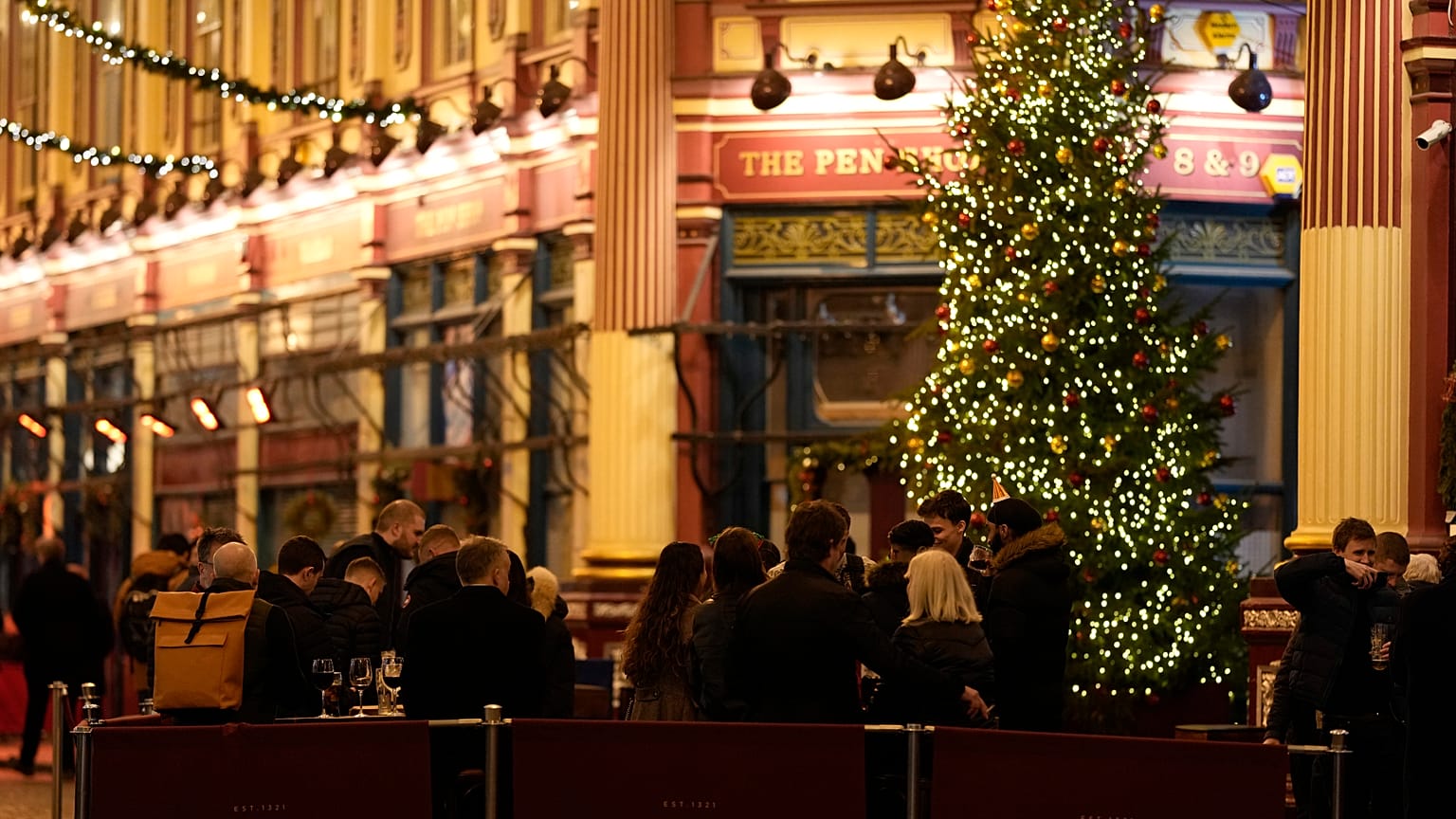 Customers drink outside a bar in London, Friday, Dec. 17, 2021. 