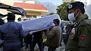 Health workers carry the coffin of a victim, who died in a stampede at the Mata Vaishnav Devi shrine, at a hospital in Katra, India, Jan. 1, 2022.
