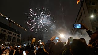 Spectators at the boulevard Unter den Linden watch fireworks as they celebrate the New Year near the Brandenburg Gate in Berlin, Germany, Jan. 1, 2022. 