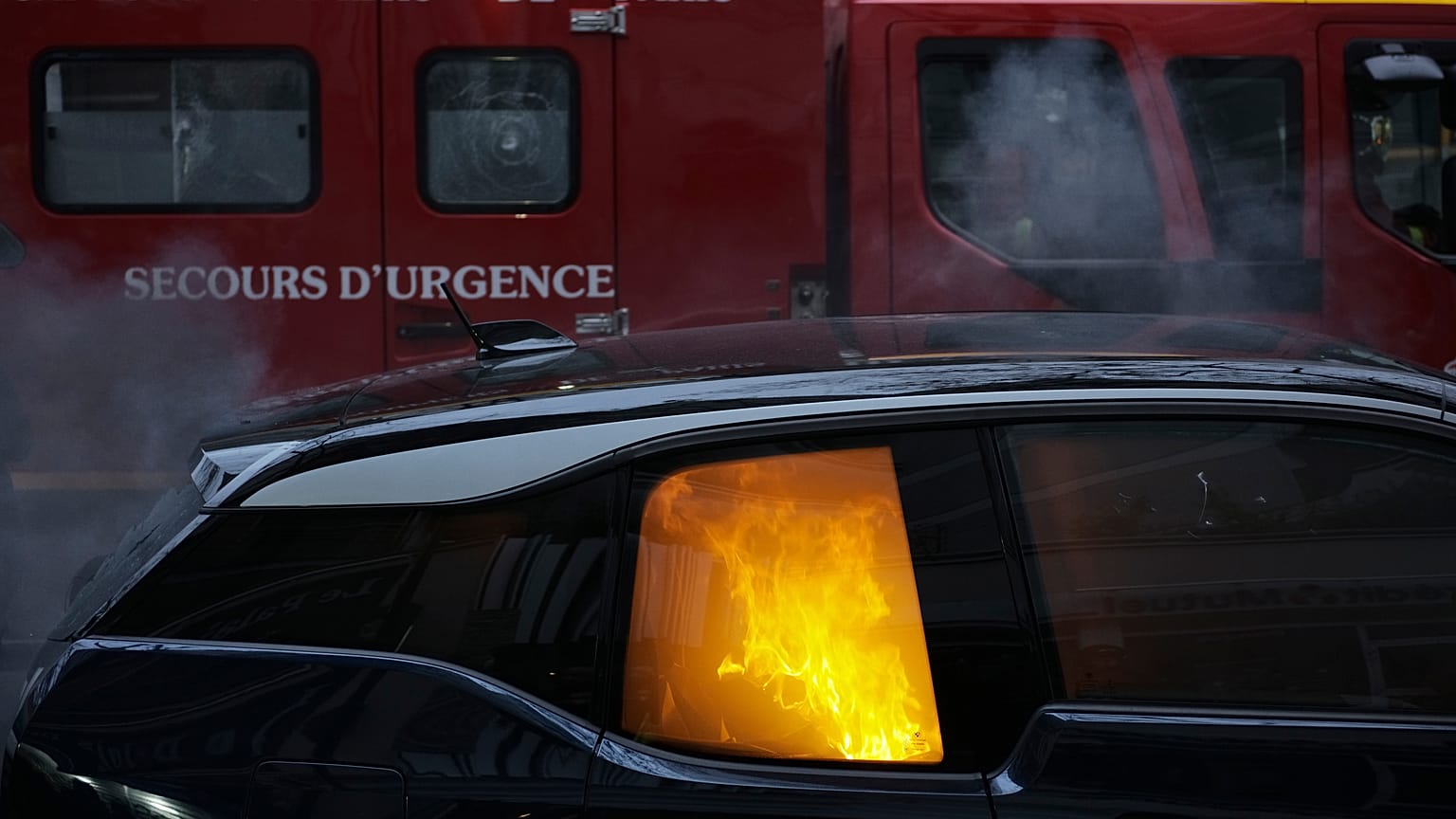 A firefighters truck parks by a burning car during a demonstration, Dec. 5, 2020 in Paris.