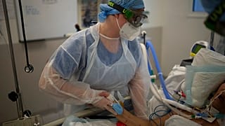 In einem Krankenhaus in Marseille hält eine Krankenschwester einem Covid-Intensivpatienten die Hand