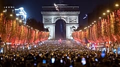 Az újév beköszöntét ünneplő emberek a párizsi Champs-Élyées sugárúton 2022. január 1-jén.