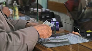 A man changes Turkish lira for US dollars at a currency exchange shop, in Ankara, Turkey, Monday, Dec. 13, 2021.
