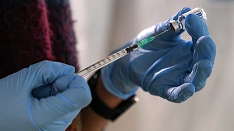 Staff member from the National Health Organisation (EODY) prepares a booster Johnson and Johnson vaccine against COVID-19 at Karatepe refugee camp, Lesbos, Greece.