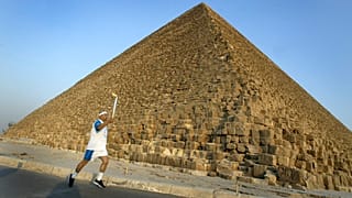 Az egyiptomi Ajman HUSZEIN viszi az olimpiai láng fáklyáját Kheopsz fáraó gízai piramisa előtt 2004. június 11-én.