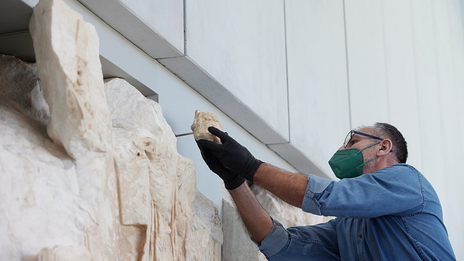 Συντηρητής του Μουσείου της Ακρόπολης τοποθετεί Παρθενώνειο θραύσμα, κατά τη διάρκεια της τελετής απόδοσης 10 Παρθενώνειων θραυσμάτων από το Εθνικό Αρχαιολογικό Μουσείο