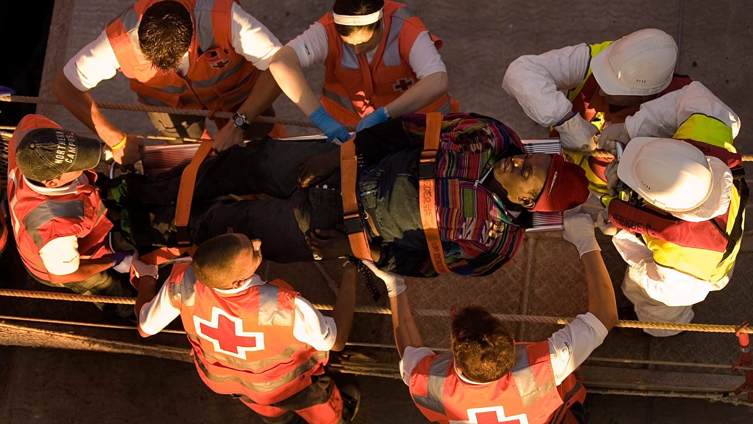 مهاجرة تُحمل على نقالة بعد وصولها مع 118 مهاجرًا آخر على متن قاربين لجزيرة الكناري، إسبانيا. 