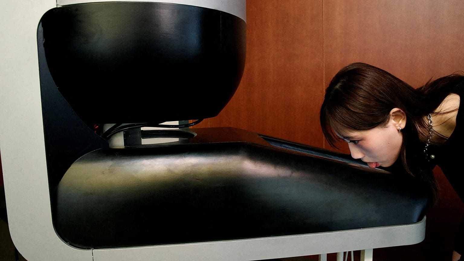Image shows a Meiji University student demonstrating a lickable TV screen called ‘Taste the TV’