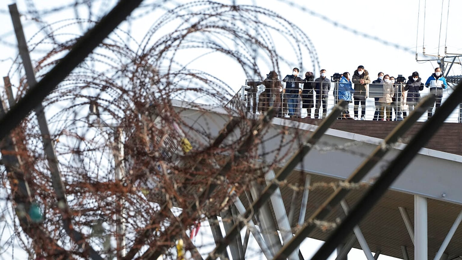 Az északot déltől elválasztó demilitarizált övezet szögesdrót akadályainak egy része - háttérben a dél-koreai kilátó a határ mellett