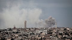 In this Thursday, Sept. 19, 2013 photo, smoke rises after a bomb was thrown from a helicopter, hitting a rebel position during heavy fighting in Idlib province, Syria. 