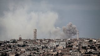 In this Thursday, Sept. 19, 2013 photo, smoke rises after a bomb was thrown from a helicopter, hitting a rebel position during heavy fighting in Idlib province, Syria.