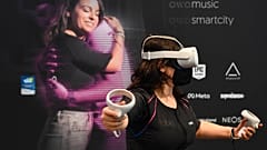 A CES attendee demonstrates the Owo vest, which allows users to feel physical sensations during metaverse experiences such as virtual reality games