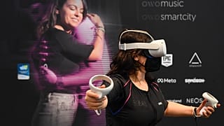 A CES attendee demonstrates the Owo vest, which allows users to feel physical sensations during metaverse experiences such as virtual reality games