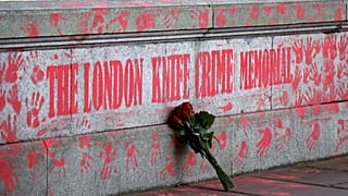 A bouquest is left at a mural to highlight knife crime in London on April 30, 2021.