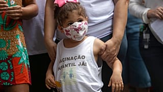 "Vacinação Infantil, Já!", lê-se numa blusa envergada por criança durante a manifestação pelas vacinas contra a covid-19