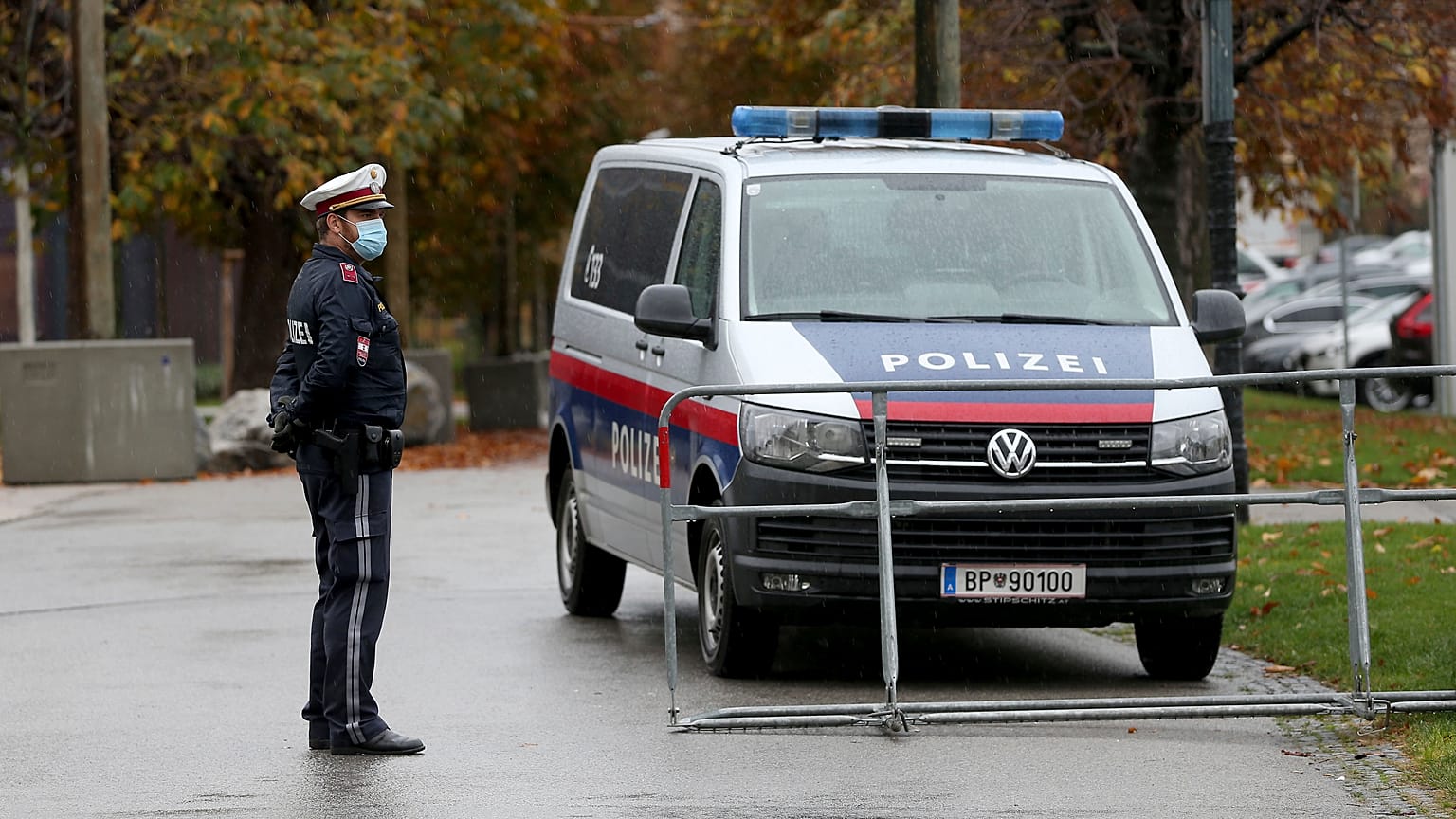 A police officer with mask standing behind a barrier in downtown Vienna.