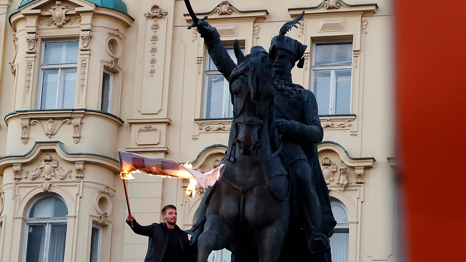 A man burns a flag during a protest against vaccination and coronavirus measures in Zagreb