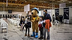 Kinder posieren für ein Foto mit dem "Impf-Maskottchen" in einem Impfzentrum in Lissabon (Dezember 2021) 
