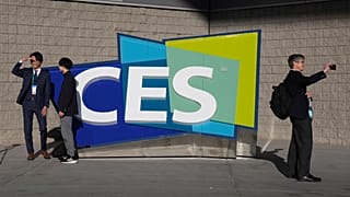 People take pictures in front of a sign during the CES tech show Thursday, Jan. 6, 2022, in Las Vegas.