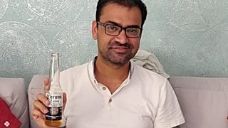 كوفيد كابور وهو يشرب بيرة كورونا في منزل أحد الأقارب في مومباي، الهند. 