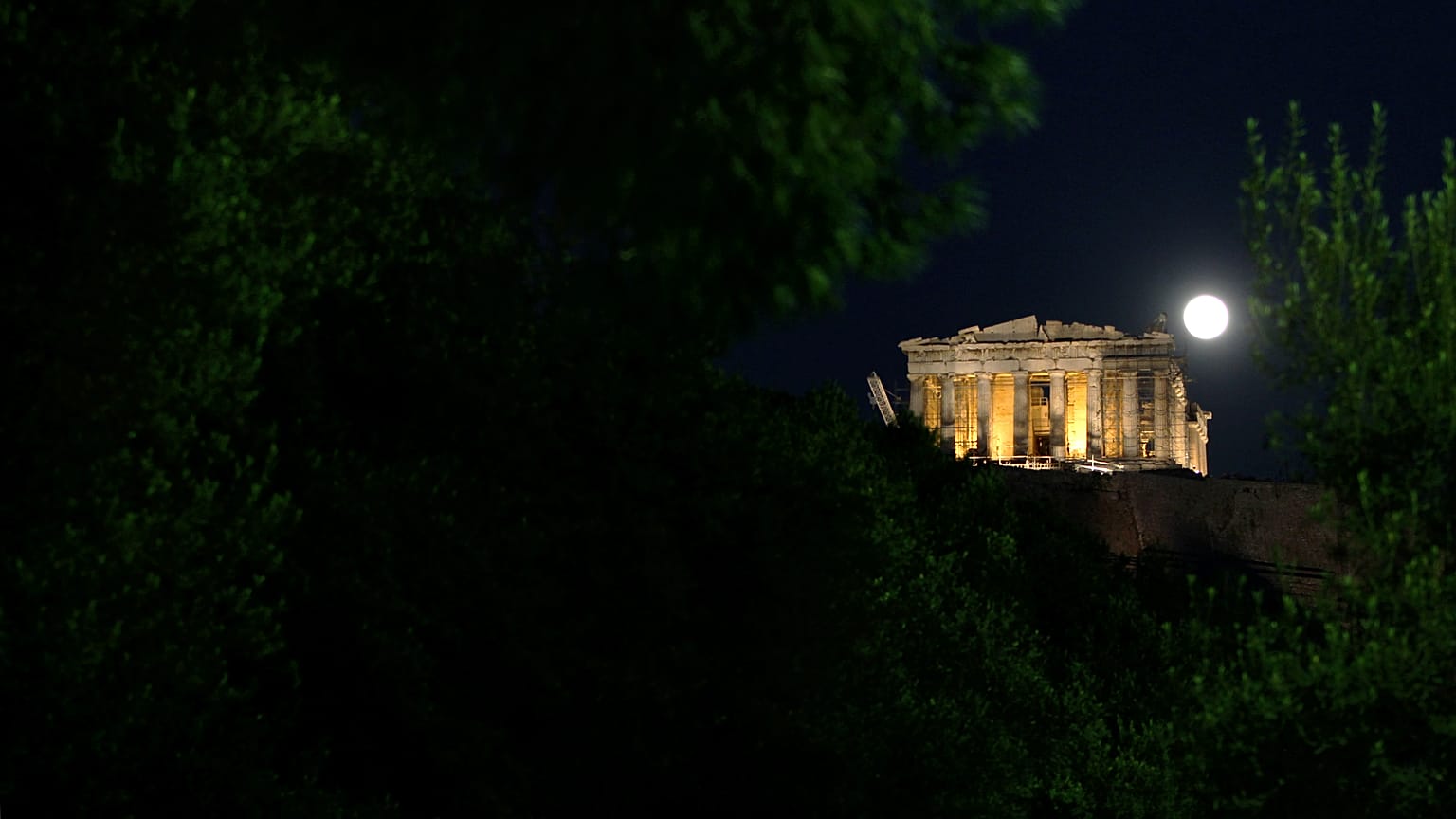 The full moon rises over ancient Parthenon temple in central Athens, Wednesday, Jan.19, 2011
