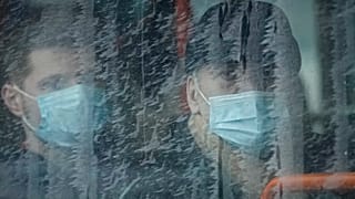 FILE - People watch from a passing bus health workers protesting outside the government building in Bucharest, Romania, Tuesday, Dec. 28, 2021