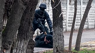 Kazakistan'ın Almatı kentinde bir göstericiye müdahale eden bir çevik kuvvet polisi 