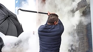 Employees of Democrats' Party use a fire extinguisher against protesters who try to invade at the headquarters in Tirana, Albania, Saturday, Jan. 8, 2022.