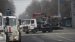 Aufräumen in Almaty: Ein ausgebranntes Fahrzeug wird abtransportiert
