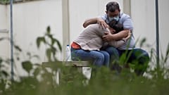 A couple embraces as they wait for information about missing relatives after a massive slab of rock toppled onto pleasure boaters at Furnas reservoir on Saturday