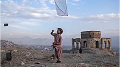 طفل يلهو بطائرة ورقية على تلة في كابول، أفغانستان.