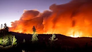 Seen in a long camera exposure, the Caldor Fire burns on Sunday, Aug. 29, 2021, in Eldorado National Forest, Calif.