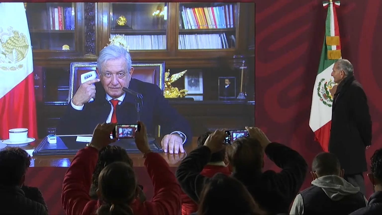 El presidente de México Andrés Manuel López Obrador se toma la temperatura durante su conferencia de prensa habitual, 11/1/2022, Ciudad de México, México