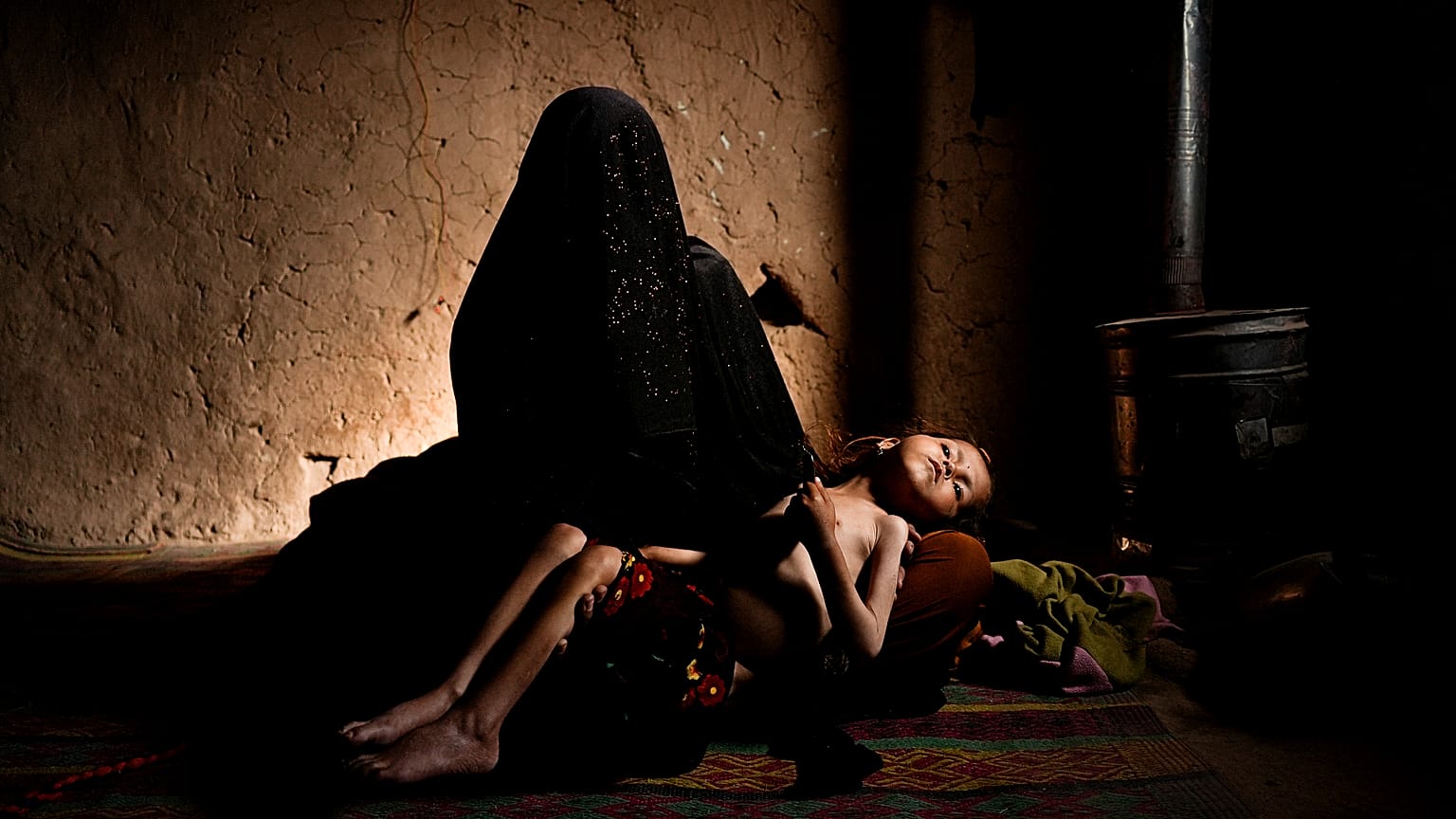 Une femme afghane tient dans ses bras sa fille de 4 ans qui souffre de malnutrition. 16 décembre 2021, Afghanistan.