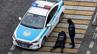 Kazakistan'ın Almatı şehrinde gözaltına polis tarafından gözaltına alınan bir kişi