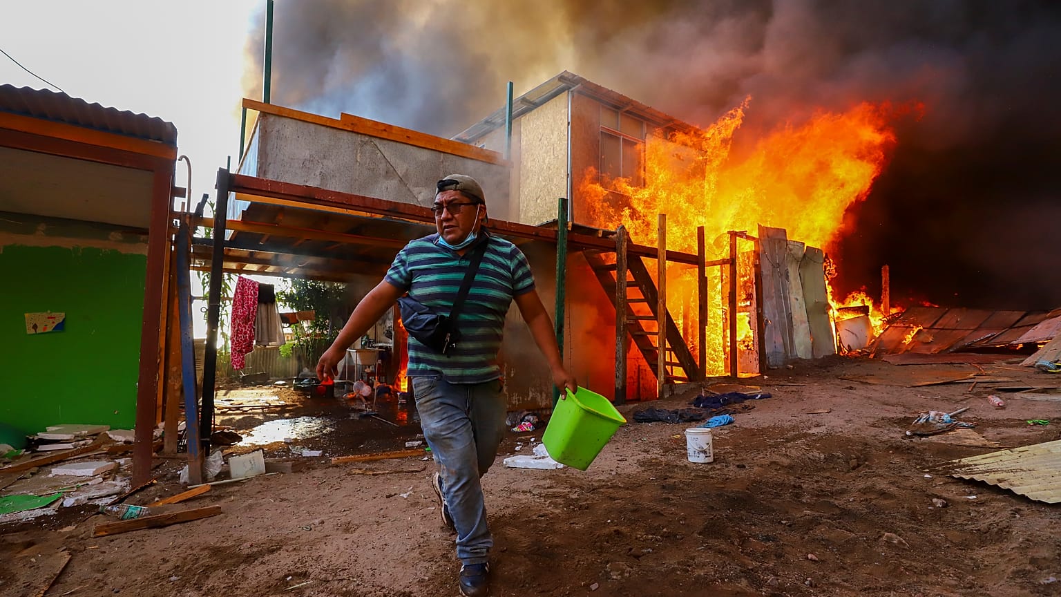 Un vecino ayuda a apagar el incendio de Laguna Verde, en la ciudad chilena de Iquique, el lunes 10 de enero